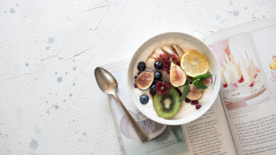 a bowl of yogurt and fruit on top of a magazine